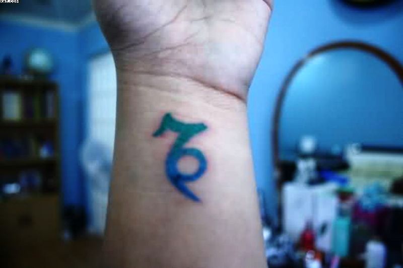 Blue And Green Capricorn Tattoo On Wrist