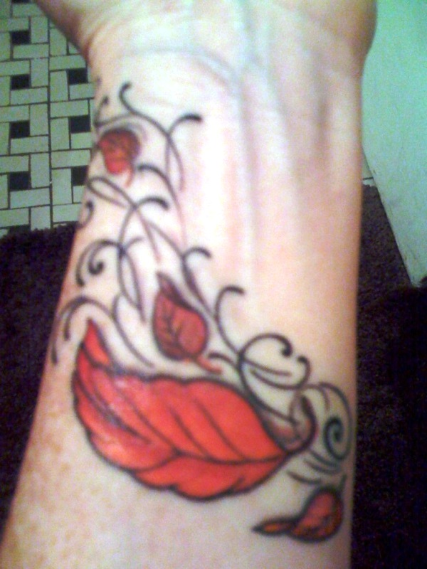 Orange Colored Leaf Tattoo On Wrist